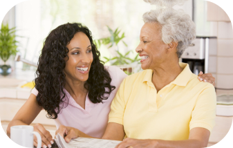 caregiver and old woman smiling at each other