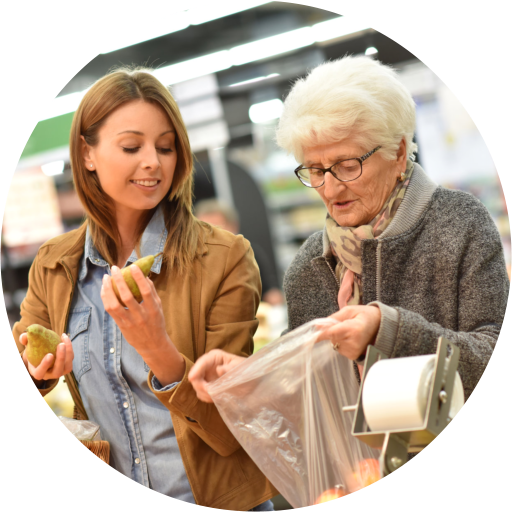 caregiver assisting an elderly woman in grocery shopping